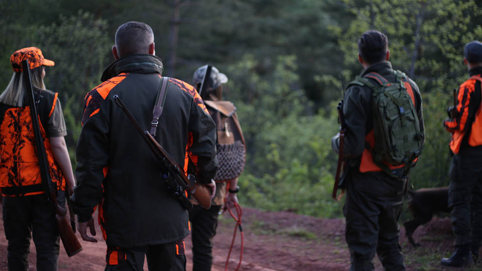 Group of hunters standing in field